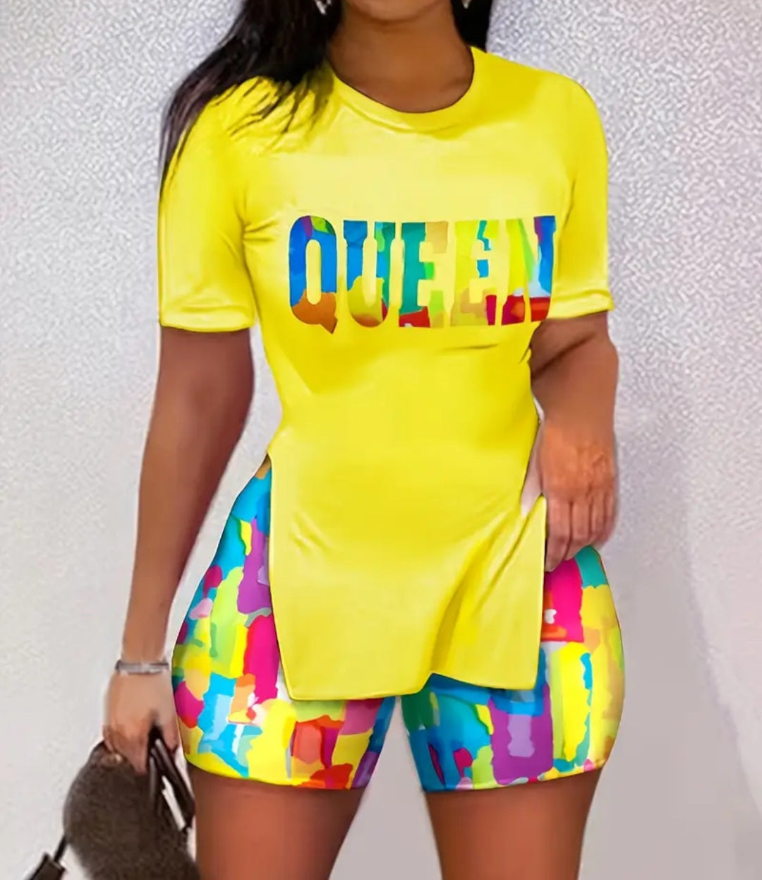 Trendy Women's 2-Piece Fashion Set with Shorts featuring a vibrant yellow top that reads 'QUEEN' in colorful letters, paired with multi-colored shorts, ideal for summer vacations and casual outings.
