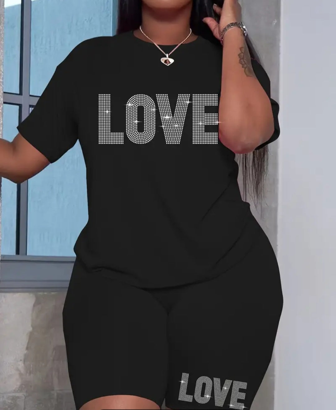 Plus Size Women's Love Set - A stylish and comfortable outfit featuring a playful love-themed print, displayed by a model in a chic black top and shorts.